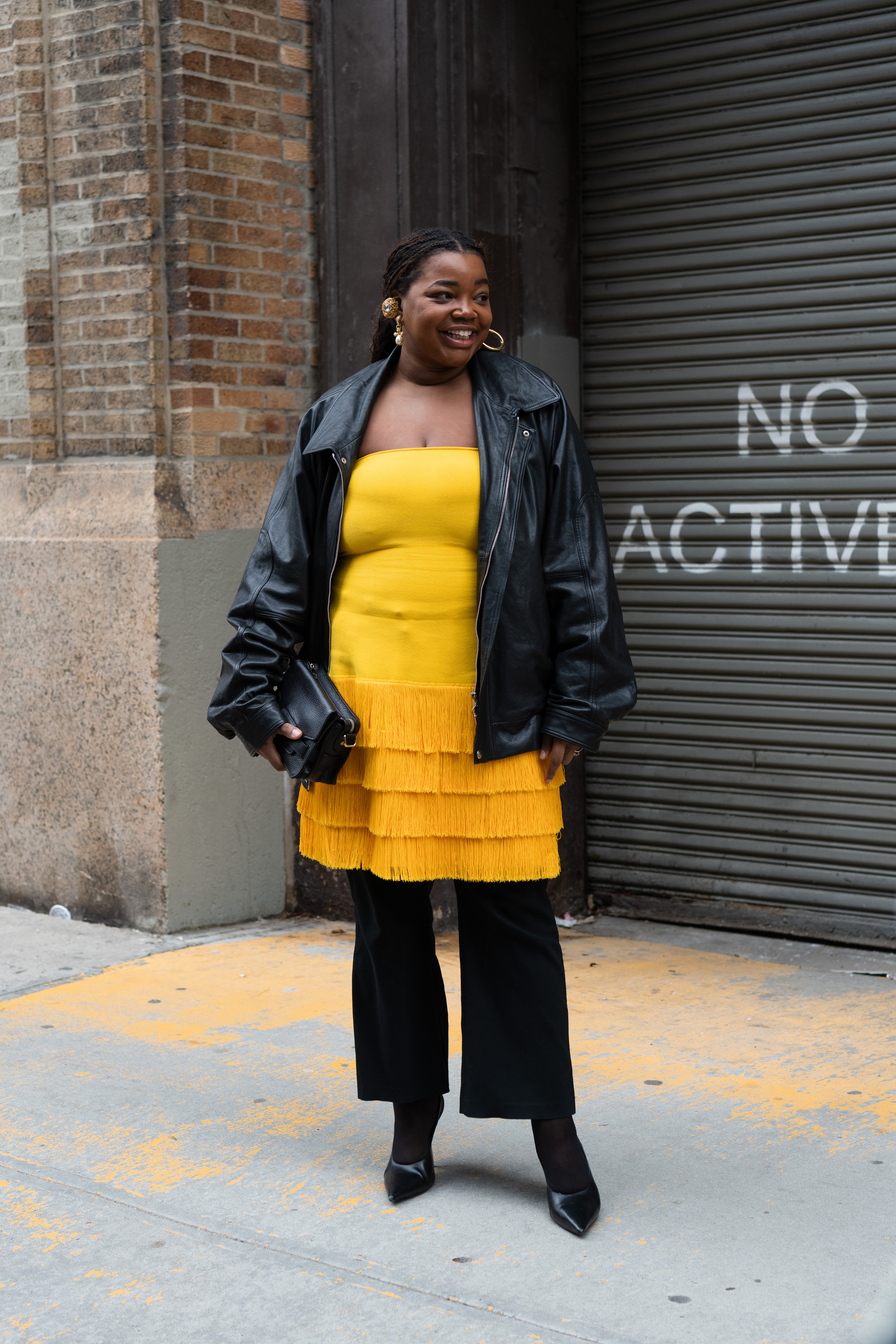 woman wearing yellow dress, black jacket, and black pants