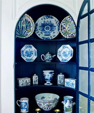 Blue inbuilt cabinet with blue and white china on display