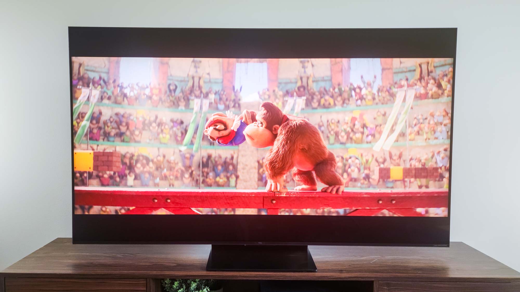 A TCL QM7K QD-Mini LED TV on a side table