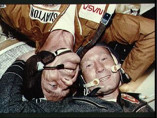 Astronaut Deke Slayton (left) and Cosmonaut Aleksey A. Leonov are photographed together in the Soyuz Orbital Module during the joint U.S.-USSR Apollo Soyuz Test Project (ASTP) docking in Earth orbit mission. They are the respective commanders of their cre