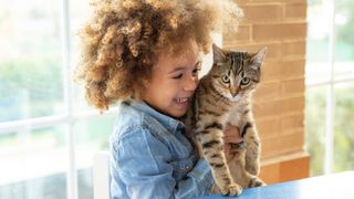 Funny cat jokes - little boy laughing while holding cat