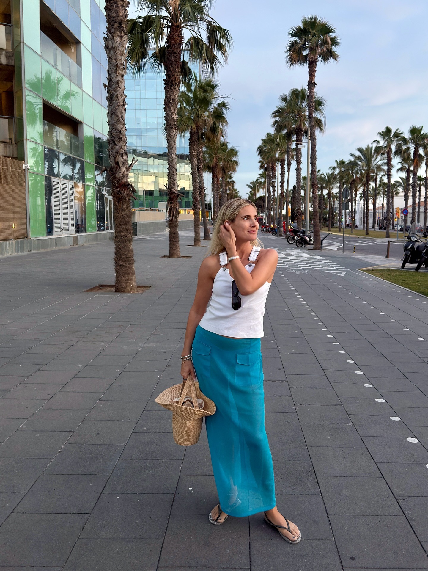 Woman in white tank top and blue sheer skirt.