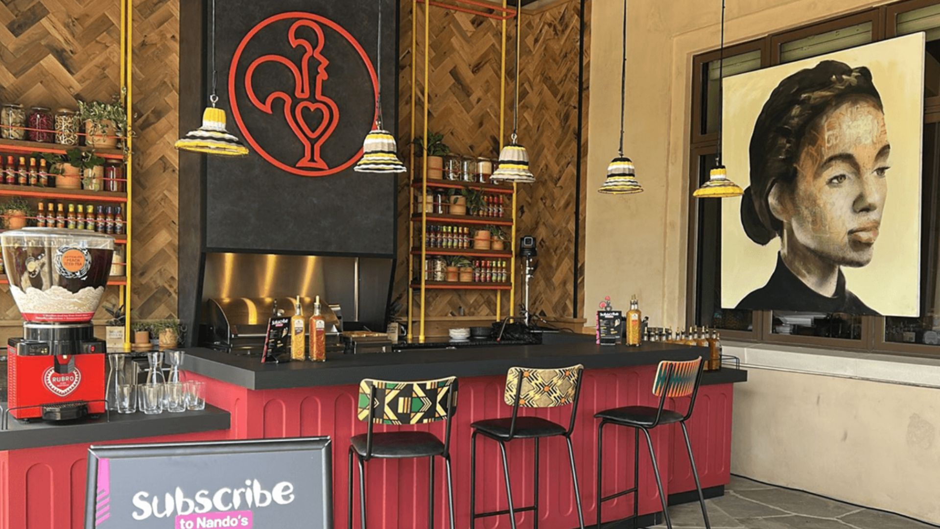 an image of the interior of the pop up Nando's restaurant. It shows the same bar and seats as the last image but from a different angle