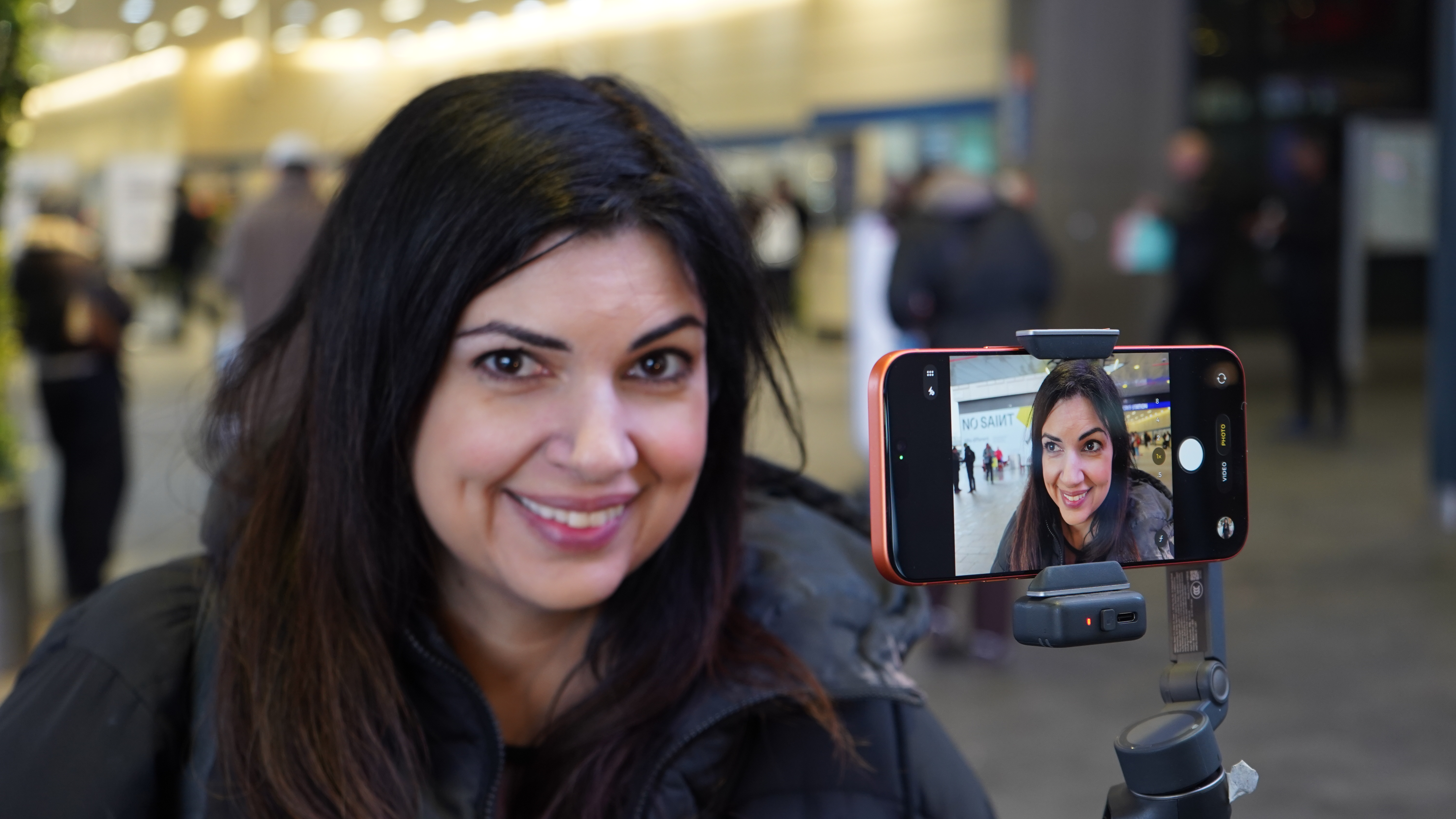 Ariane Sherine shooting a selfie with the DJI Osmo Mobile 8 and an iPhone 17 Pro Max