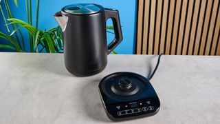 an all-black ninja electric kettle with a precision temperature base for specialty tea and general kitchen use photographed making coffee