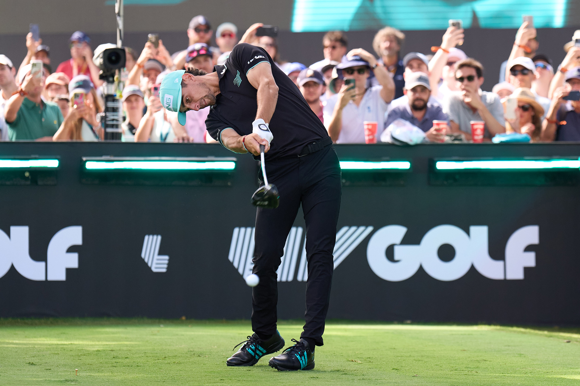 Joaquin Niemann of LIV Golf just past impact with driver after hitting a tee shot