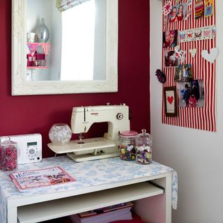 sewing room with sewing machine and mirror on wall