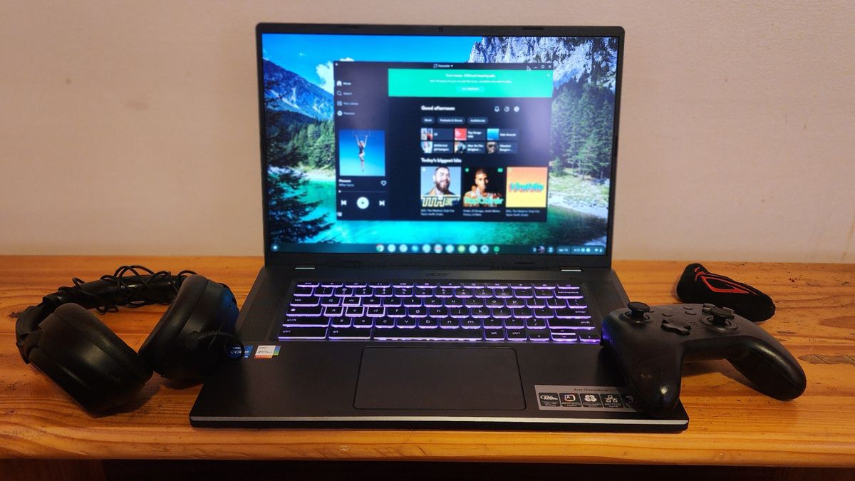 The Acer Chromebook 516 GE facing forward on a desk with gaming accessories like a gamepad and headset.