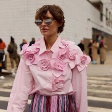 woman in a rose shirt wearing a rose fragrance