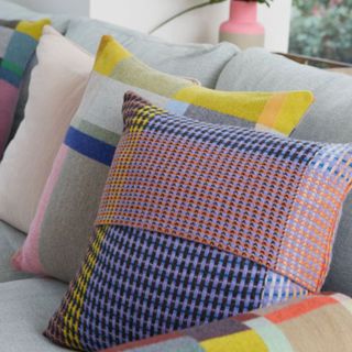 Multi-colored houndstooth throw pillows on gray sofa