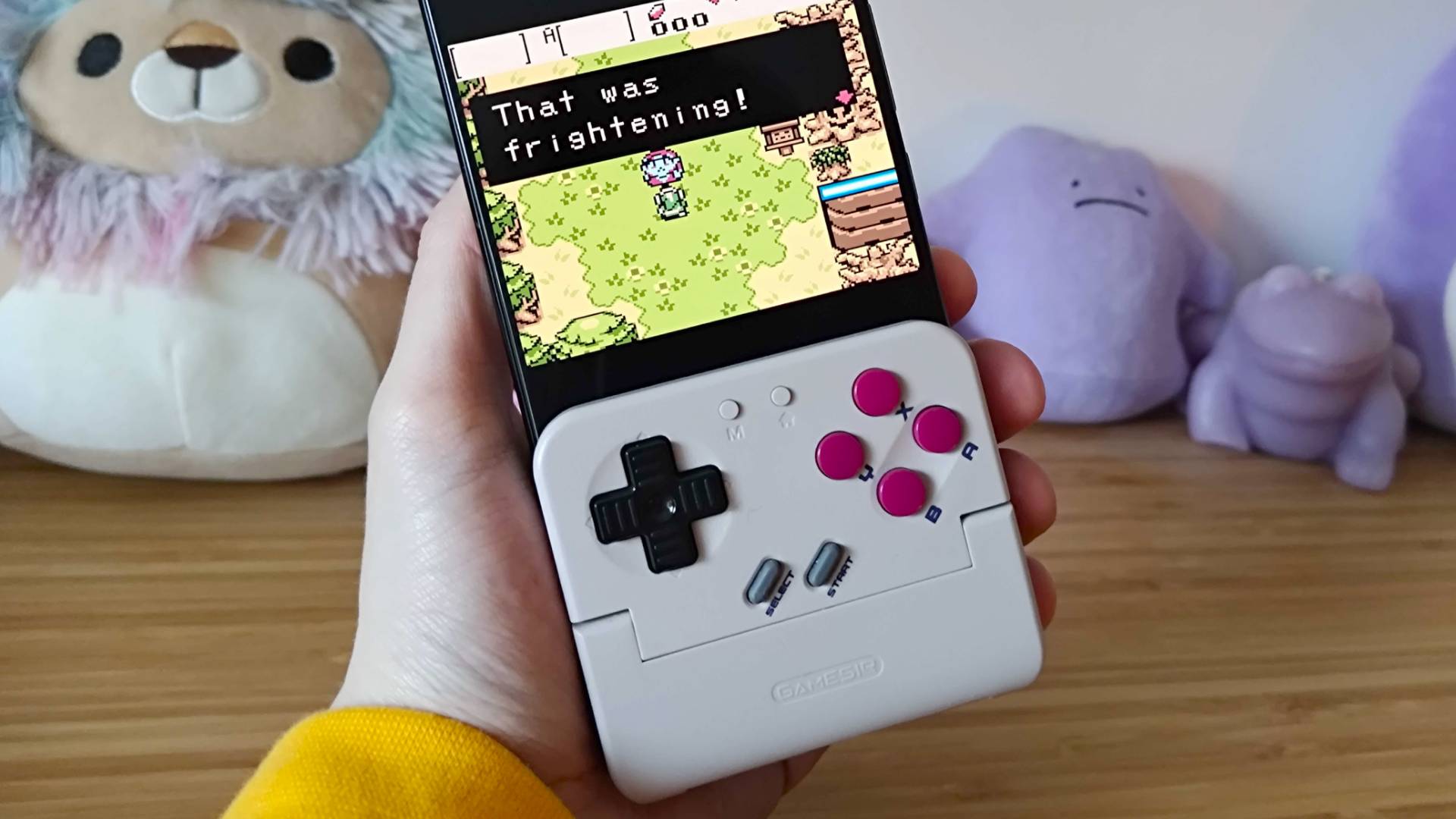 Close up of hand holding Gamesir Pocket Taco attached to Asus ROG Phone 9 Pro with Zelda: Oracle of Ages gameplay on display.