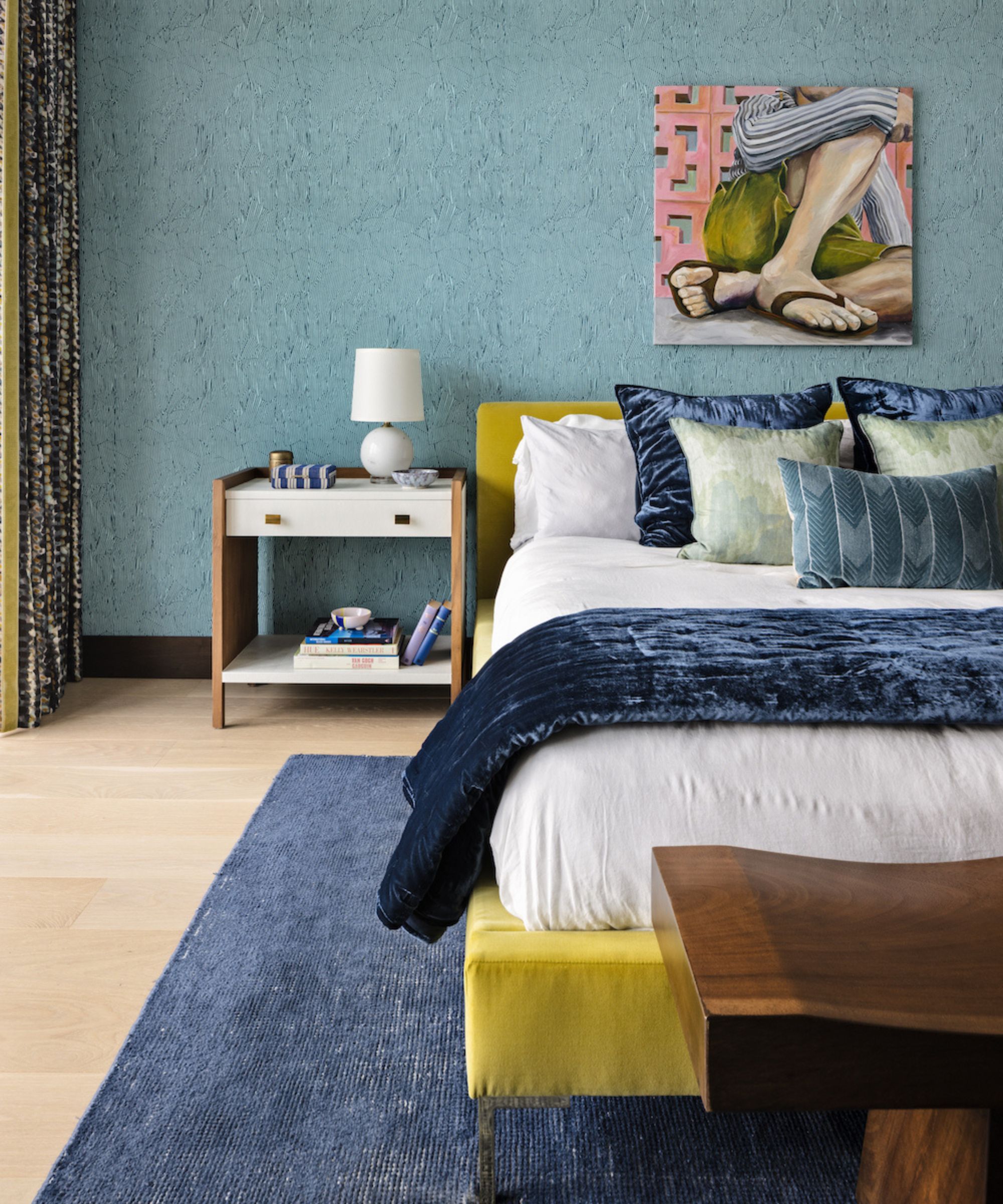 colorful bedroom with blue wall, yellow bed and blue and green cushions