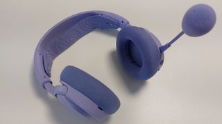 The SteelSeries Arctis Nova 3 X seen on a desk. This is the Lavender colourway.