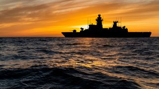 Warship at sunset in the sea