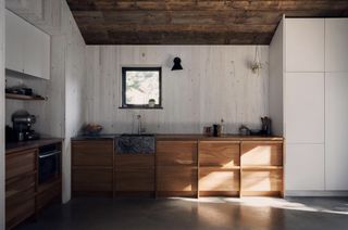 A kitchen with butcher block countertop and marble sink