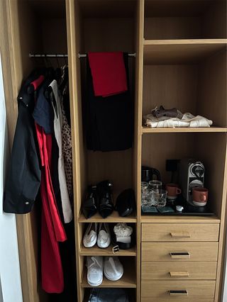 A photo of my closet situation at Le Grand Quartier hotel in Paris, with dresses and coats hung up and shoes laid out.