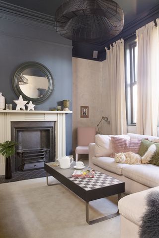 soft pink living room with a black feature wall, pink sofa and statement coffee table