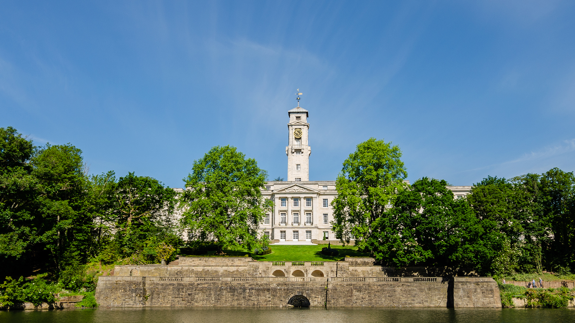 Trent building at Nottingham University with the Highfields Lake in foreground, with clear blue skies above.