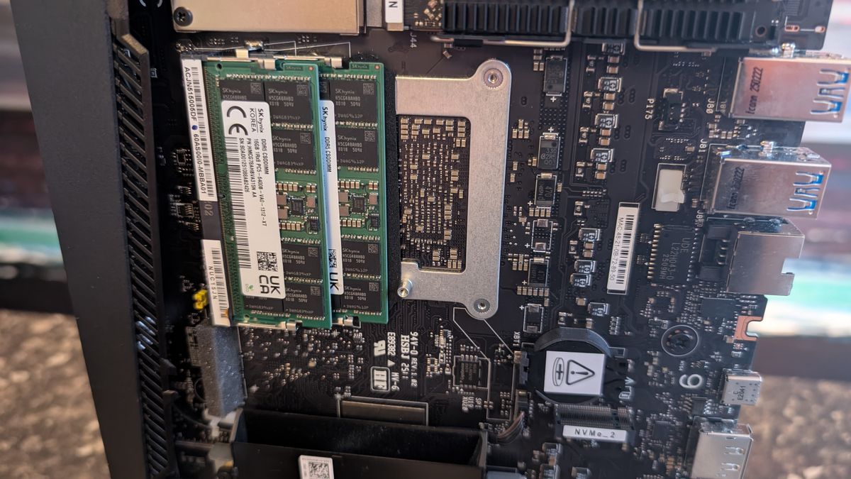 The Asus ROG NUC photographed on a dark marbled worksurface with a painted sunset in the background.