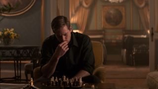 Armie Hammer sits thinking while playing chess in The Man From Uncle.