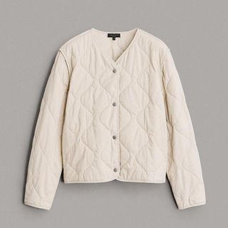 flat lay of rag & bone cream quilted light cropped jacket on a grey background