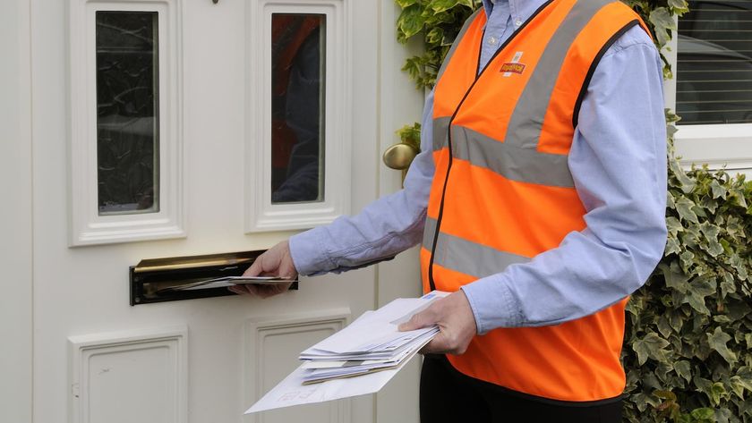 Royal mail postwoman at the front door of a house delivering mail to a customer
