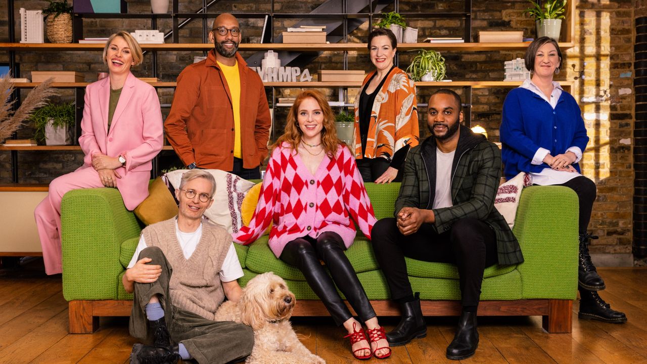 Men and women sat and stood around green sofa