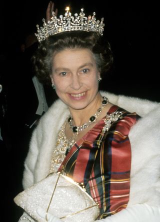 Queen Elizabeth II heading to a state banquet in a tartan sash and gown