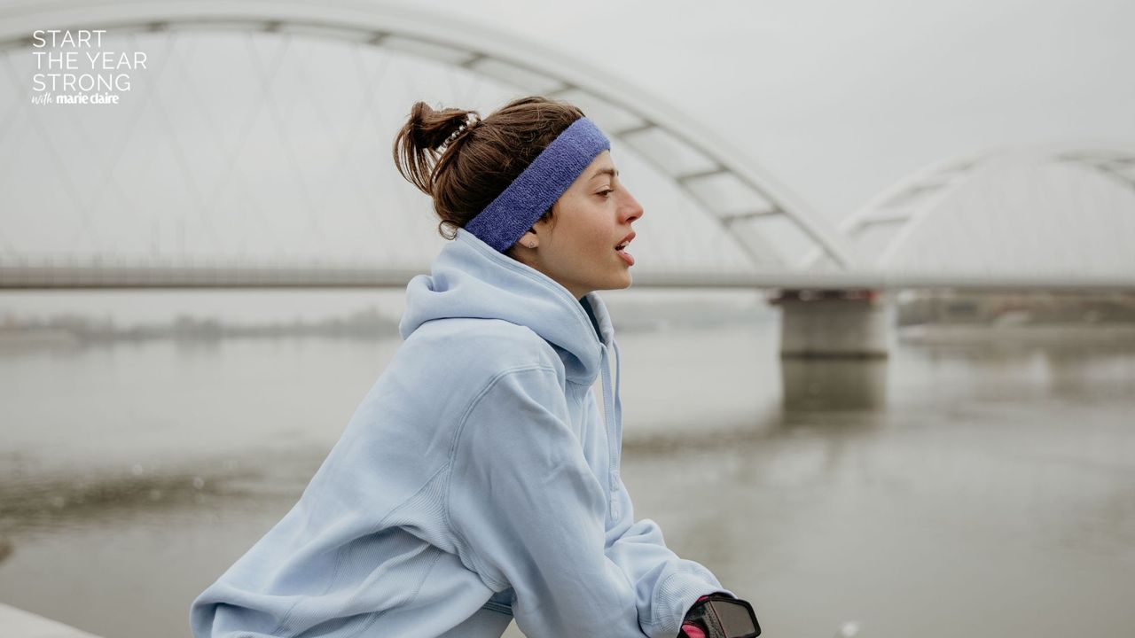 A woman doing a cold weather workout in headband and hoodie