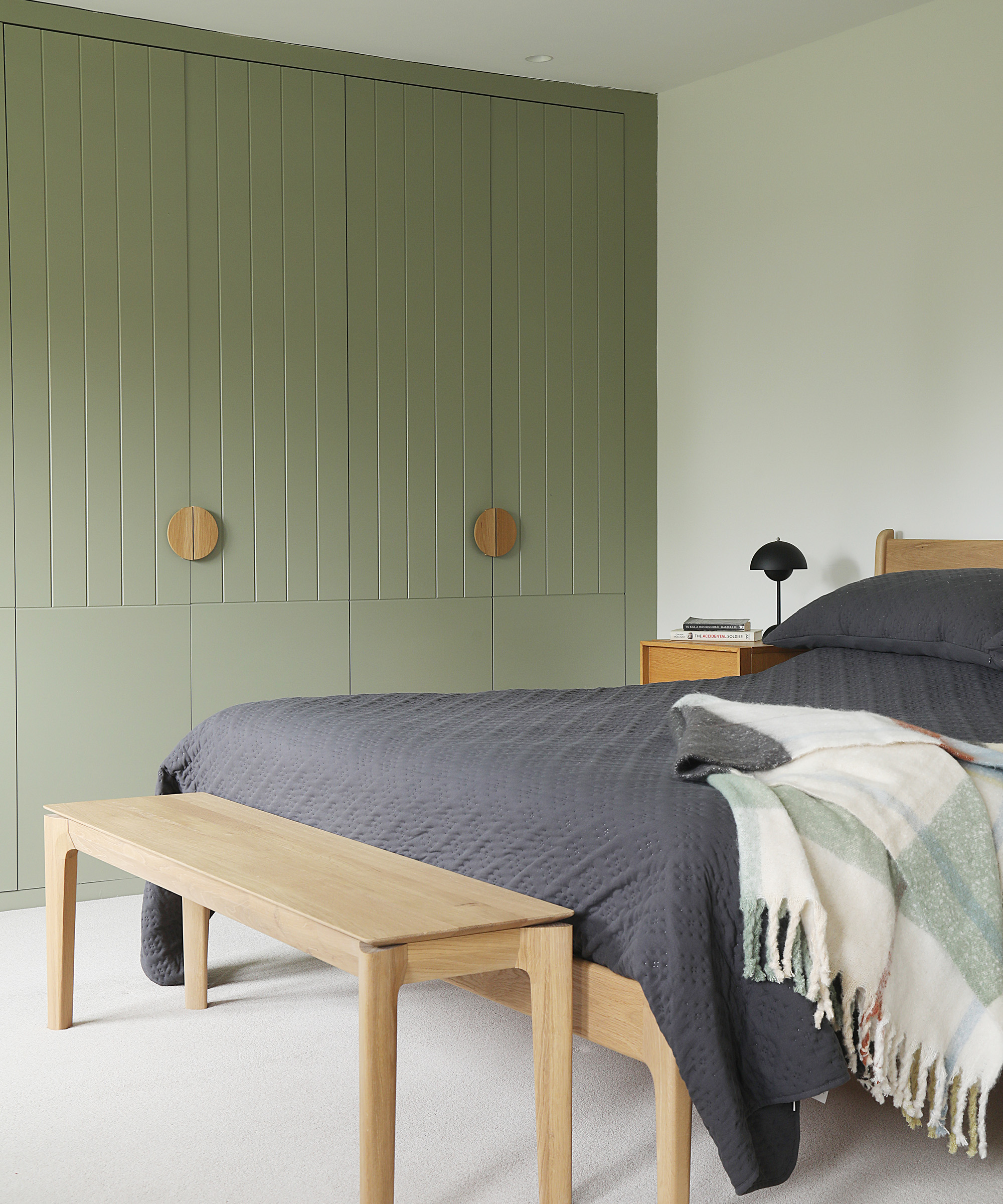 A double bedroom with built-in olive green wardrobe