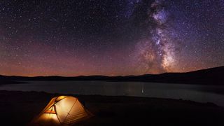 Camping with kids: a tent photographed at night beneath the Milky Way