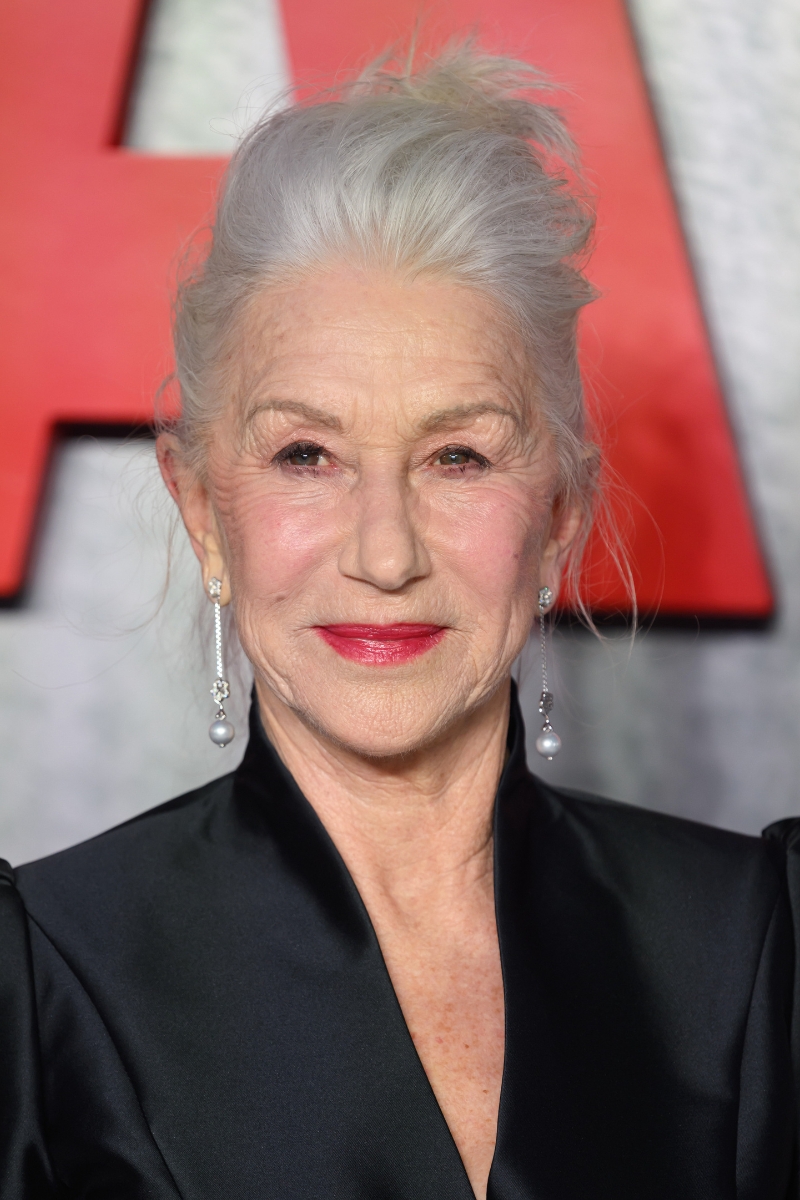 Dame Helen Mirren is pictured with her hair in an updo and wearing a red lip and black blazer-style top at the "MobLand" Global Premiere at the Odeon Luxe Leicester Square on March 27, 2025 in London, England.