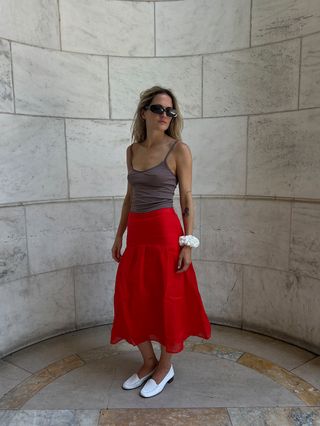 Eliza Huber wearing a brown camisole tank top and red midi skirt from J.Crew's collab with MNZ.