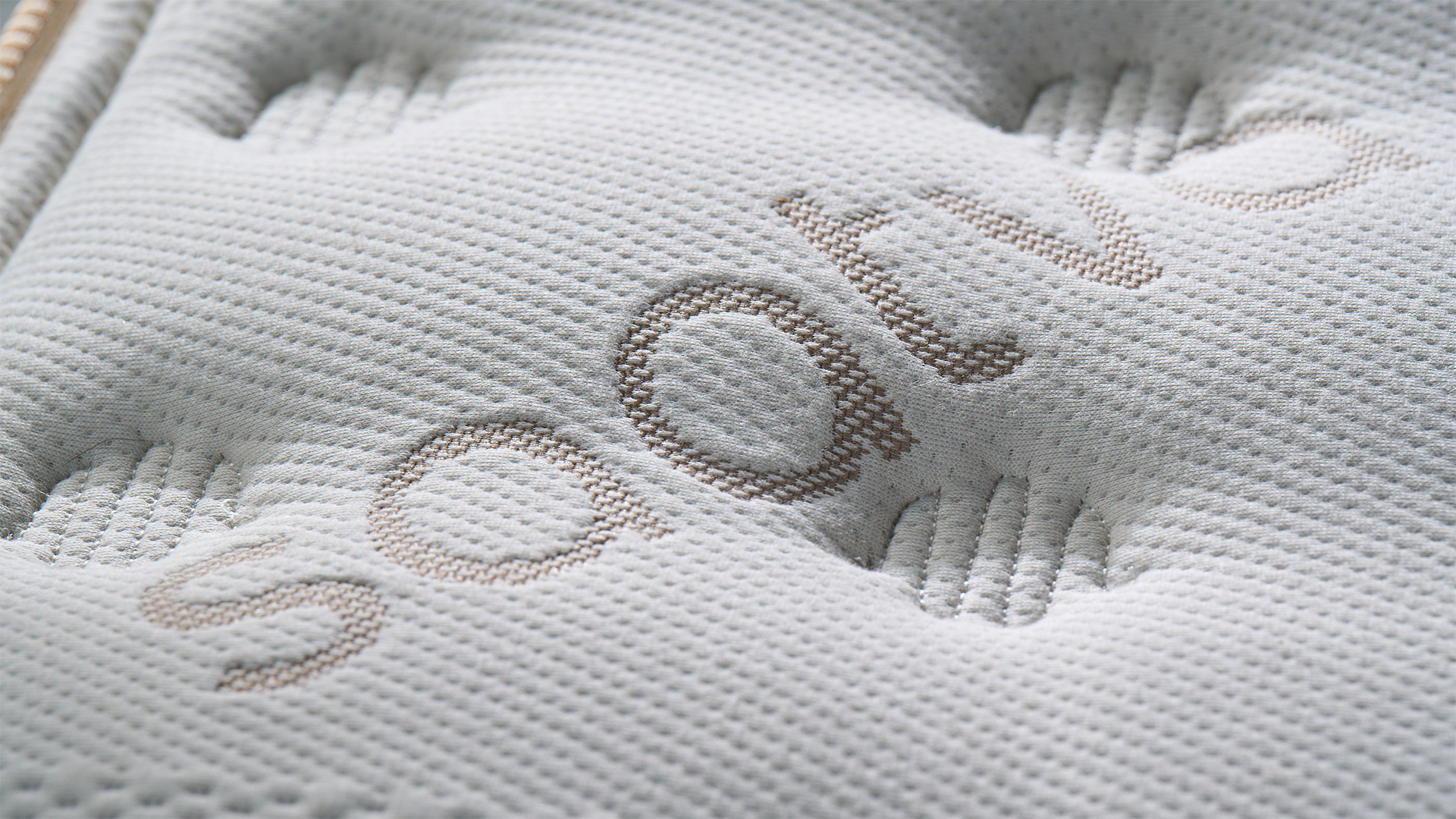 A close up of the Saatva Classic mattress cover, showing the hand tufted finish and stitched details
