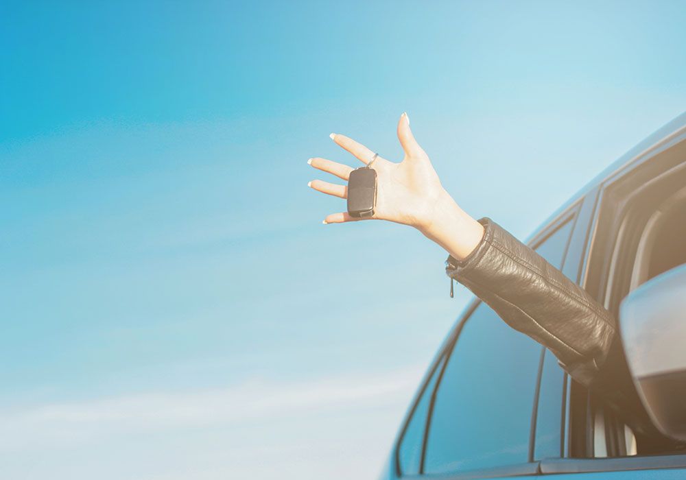 woman waving hand out car window