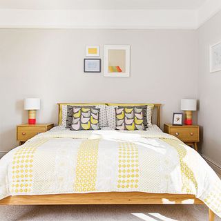 bedroom with white wall and cushions on bed