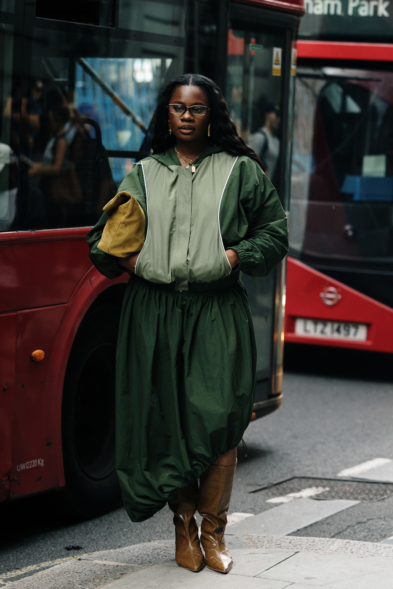 woman wearing green jacket, green bubble skirt, and brown boots