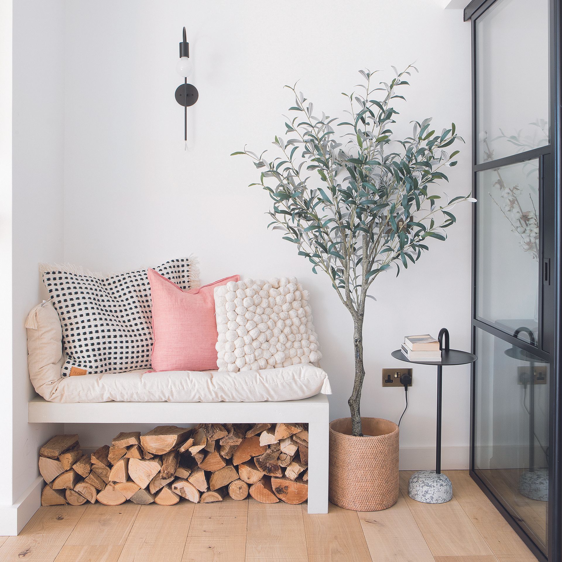 Living room with bench seating with linen cushions and plant.