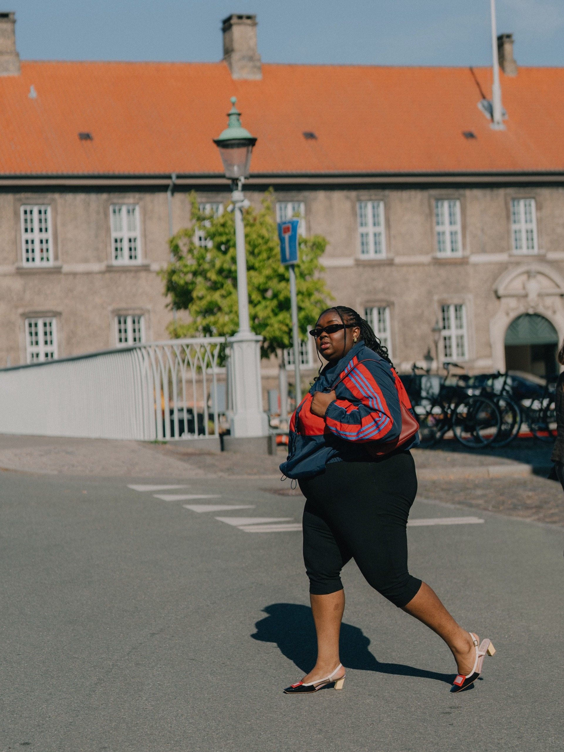 Woman wearing a track jacket and capris.