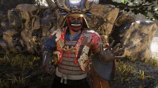 Nioh 3 emotes: A close-up of a player wearing samurai armour posing with their left hand out.