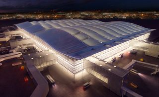 Computer-generated image of the finished airport terminal building, illuminated and with a wave-like roof