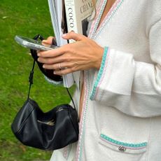 @rachelle.rowlings closeup photo holding cell phone wearing chanel cardigan and the row 90s bag