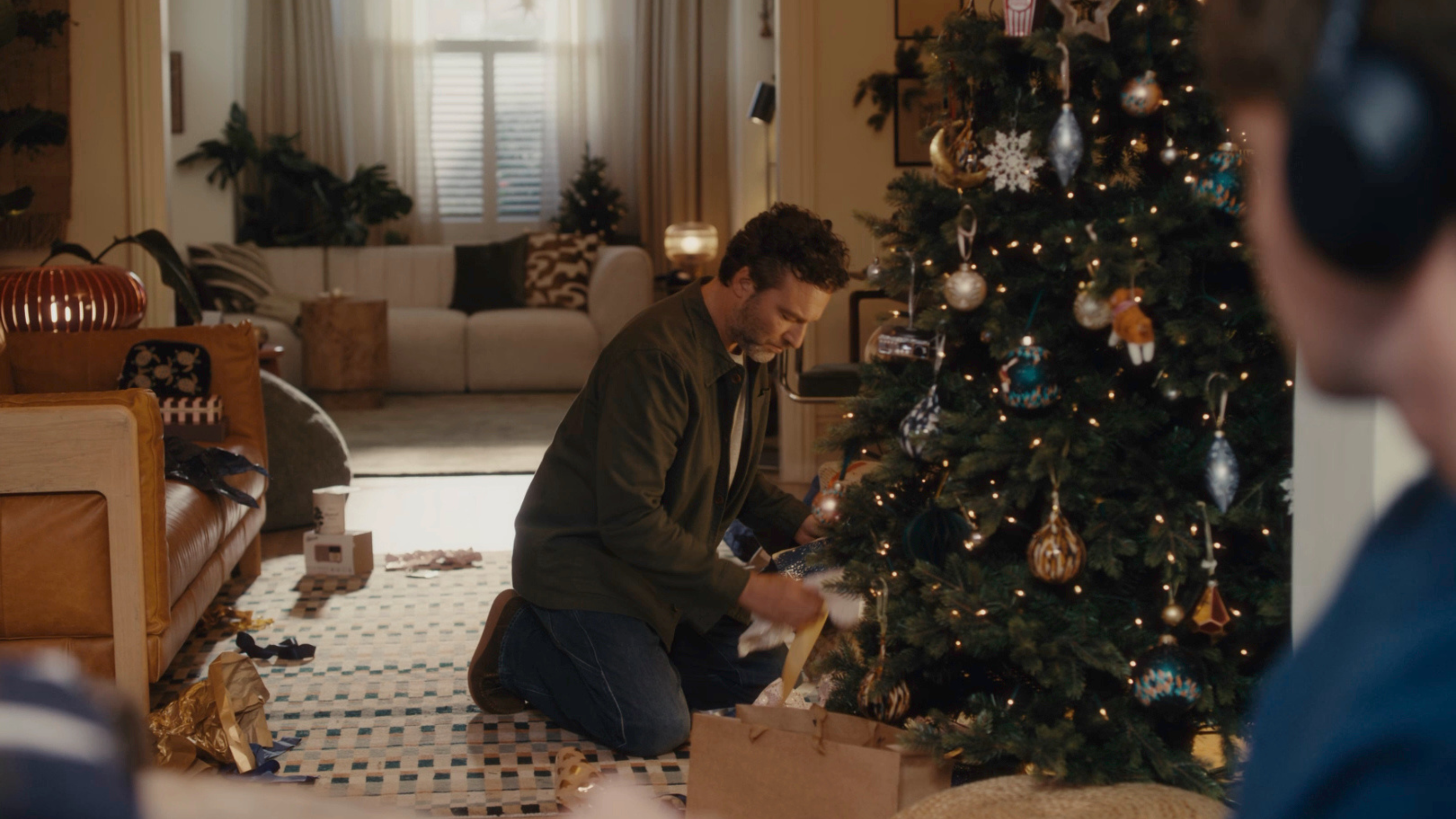 Still from 2025 John Lewis Christmas advert. It shows the dad opening his vinyl present under the tree.
