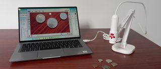 Inswan INS-3 document camera being used to display coins on table on laptop
