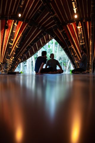 people placticing inside the ibuku-designed alchemy yoga studio in Bali