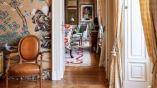 Vibrant colorful hallway with leather mid century chair and oriental design wallpaper