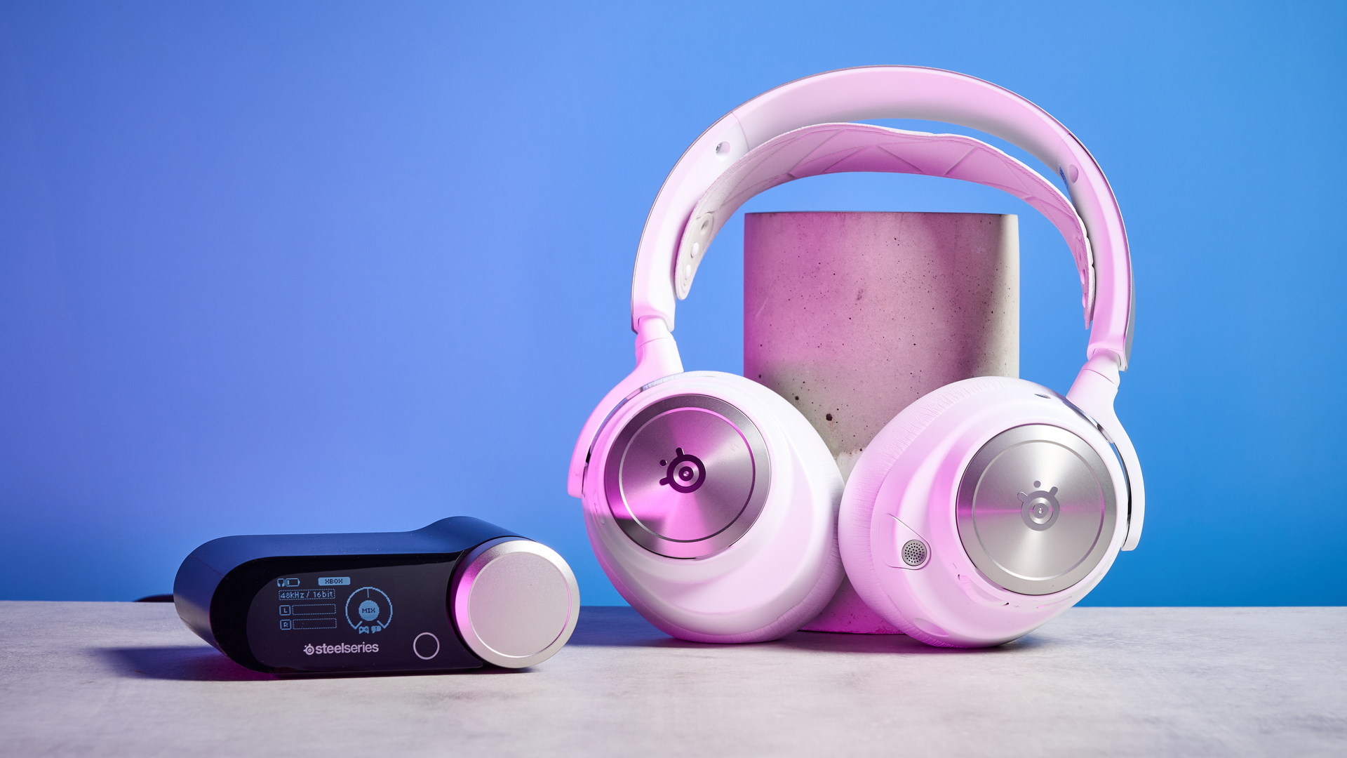 SteelSeries Arctis Nova Pro Wireless in white on a stone surface with a gentle purple reflection on the headset