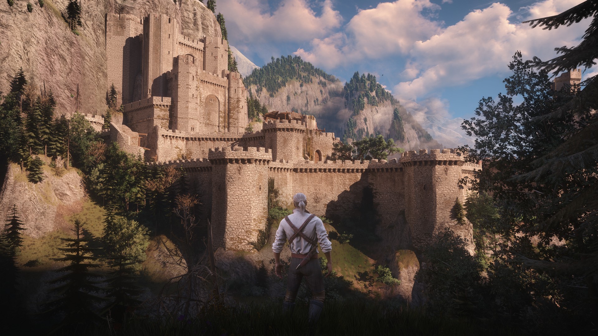 Geralt looks at Kaer Morhen, a fort in a forest, in The Witcher 3 Wild Hunt Remastered
