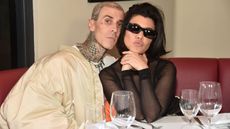 A photo of celebrities Kourtney Kardashian and Travis Barker in a restaurant