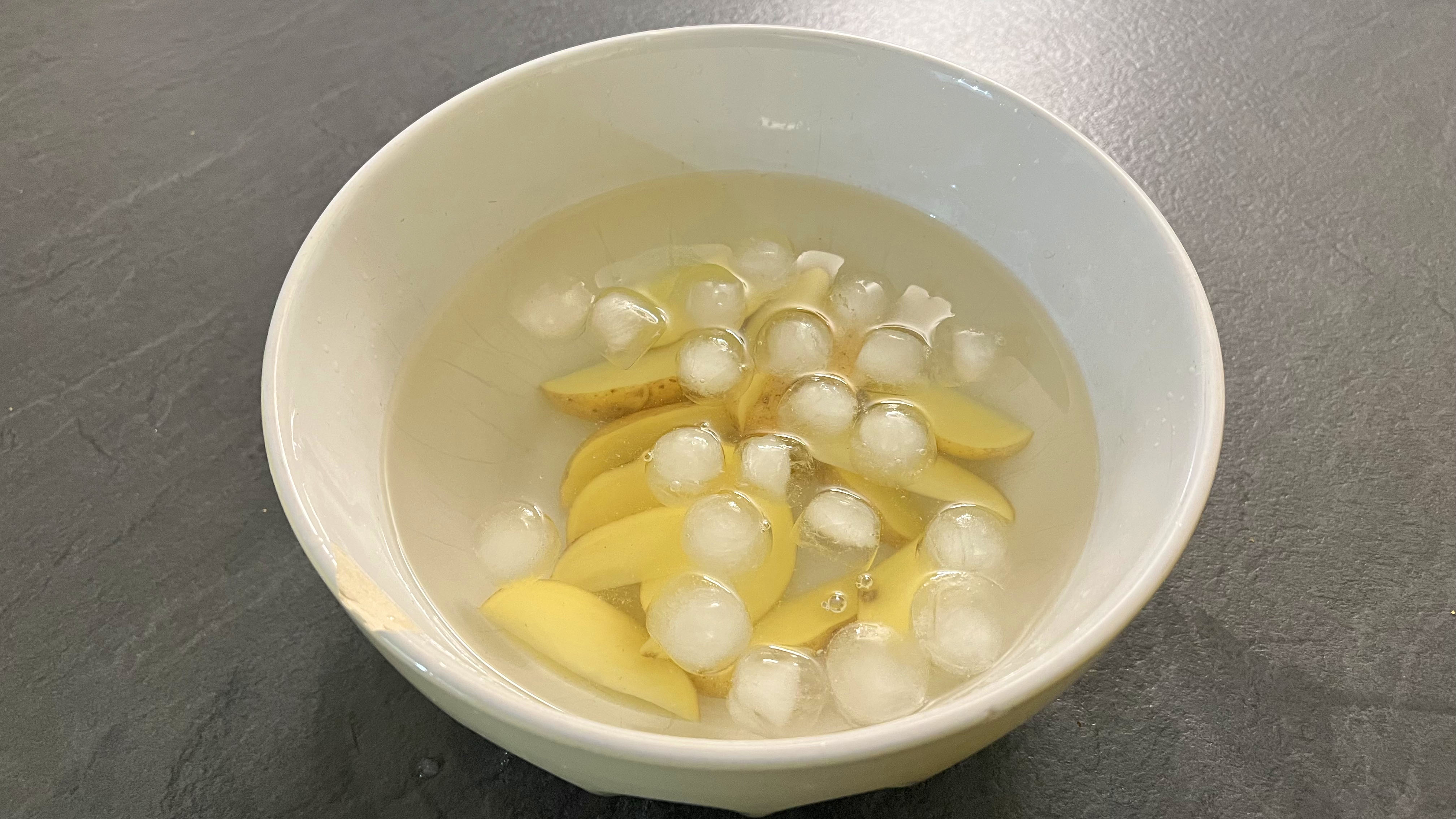 potato slices in an ice bath
